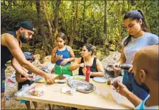  ??  ?? TAREK KAWAZ, left, sets up a family picnic along the Awali river in the valley, which will vanish if the proposed dam is built.