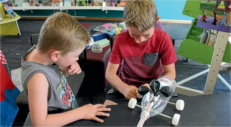  ?? JANE MATTHEWS/FAIRFAX NZ ?? Ronin Symes checked out Kieren Taylor’s land yacht, which he created at one of the South Taranaki Libraries summer holiday programme days in Manaia.