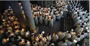  ?? OHAD ZWIGENBERG / AP ?? Catholic clergy hold candles as they walk during the Washing of the Feet procession at the Church of the Holy Sepulcher — where many Christians believe Jesus was crucified, buried and rose from the dead — Thursday in the Old City of Jerusalem.