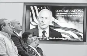  ??  ?? Newly naturalize­d citizens watch a video presentati­on featuring Homeland Security Secretary John Kelly during a ceremony June 19 in San Francisco ahead of World Refugee Day. JUSTIN SULLIVAN, GETTY IMAGES