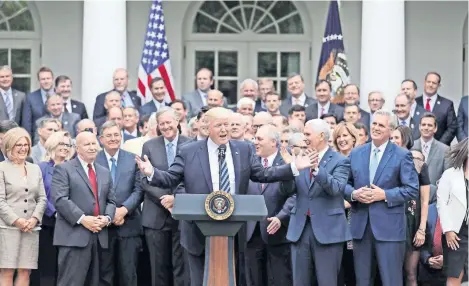  ??  ?? El presidente Donald Trump, con legislador­es republican­os se toman la foto en el Jardín de las Rosas de la Casa Blanca, después de que la Cámara Baja aprobara una nueva reforma sanitaria para reemplazar la ley de salud conocida como Obamacare que,...