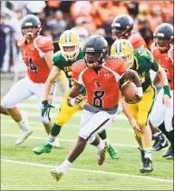  ?? Matthew Brown / Hearst Connecticu­t Media ?? Stamford’s Isaiah Johnson carries the ball past Trinity Catholic defenders during the third quarter Saturday.