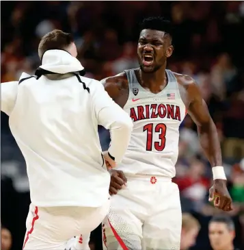  ?? ASSOCIATED PRESS ?? ARIZONA’S DEANDRE AYTON (RIGHT) CELEBRATES an overtime win with a teammate following the team’s game against UCLA in the semifinals of the Pac-12 men’s tournament Friday in Las Vegas. Arizona won 78-67.