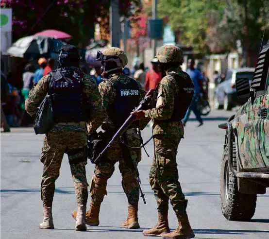  ?? CLARENS SIFFROY/AFP VIA GETTY IMAGES ?? Haitian police officers were deployed in Port-au-Prince on Saturday, as residents desperatel­y sought shelter amid the violence.