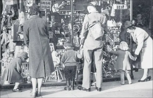  ??  ?? From above: children and their parents peruse a toyshop window in 1940; young Glaswegian­s don gas masks for a mock attack