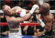  ?? ERIC JAMISON — THE ASSOCIATED PRESS FILE ?? Floyd Mayweather Jr., right, lands a punch on Conor McGregor during a super welterweig­ht boxing match in Las Vegas last August.