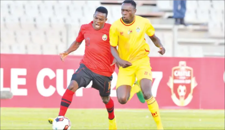  ??  ?? ON THE CHARGE . . . Zimbabwe midfielder Liberty Chakoroma (right) battles for possession against his Mozambique opponent in the opening match of the 2017 COSAFA Castle Cup in South Africa yesterday. — (Picture by COSAFA)