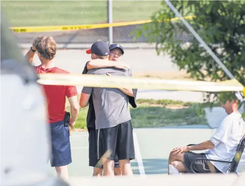  ?? JACK GRUBER, USA TODAY ?? Survivors gather behind police lines around the baseball park in Alexandria, Va., where congressio­nal Republican­s were practicing for an annual charity game with congressio­nal Democrats. The game will be played tonight as planned.