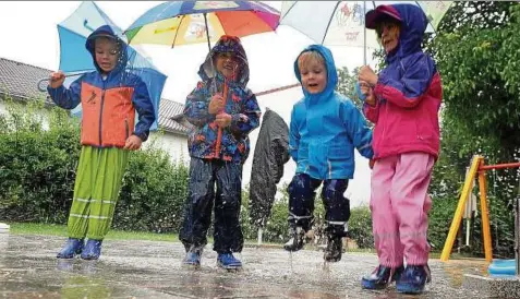  ??  ?? Wenigstens Elias, Anna, Tom und Elias haben ihren Spaß im Regen und springen von Pfütze zu Pfütze. Zu zehn kleineren Einsätzen war aber auch die Feuerwehr gefragt. Sie musste ausrücken, weil Straßen überschwem­mt wurden. Foto: Marco Schmidt