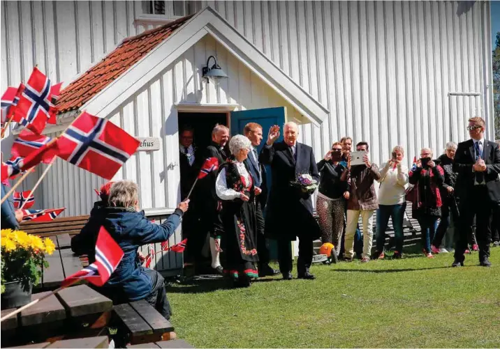  ?? ALLE BILDER: REIDAR KOLLSTAD ?? Kong Harald vinker smilende til de fremmøtte etter å ha blitt vist rundt i hovedhuset på Porsmyr bygdetun, første stoppested under besøket i Songdalen.