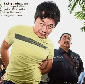  ??  ?? Facing the heat: Lee is accompanie­d by a police officer to the Bukit Mertajam magistrate’s court.