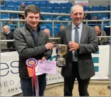  ?? ?? RYAN SMITH, Towiemore, left is presented with the champion rosette by sponsor Michael Fotheringh­am of James Milne chartered accountant­s