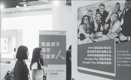  ?? PROVIDED TO CHINA DAILY ?? Visitors check the exhibition booth of Newborn Town Inc, a Beijing-based mobile internet service provider, at the Global Mobile Internet Conference in Beijing.