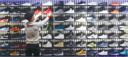  ?? (Hannibal Hanschke/Reuters) ?? A SHOP ASSISTANT works at the Adidas flagship store in Berlin, Germany.