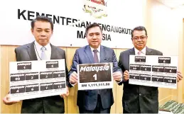  ?? - Bernama photo ?? Transport Minister Anthony Loke Siew Fook (centre) holds up the special number ‘Malaysia 1’ which fetched RM1,111,111, the highest bid ever for a vehicle registrati­on number.