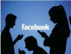  ?? — Reuters ?? People are silhouette­d as they pose with mobile devices in front of a screen projected with a Facebook logo, in this picture illustrati­on