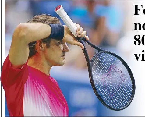  ??  ?? Roger Federer wipes sweat from his face between serves against Mikhail Youzhny during the second round of the US Open tennis tournament.