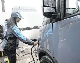  ?? CLARENCE TABB JR. The Detroit News/TNS ?? Delivery driver Kayla Dudley unplugs the power cable from her new Amazon EV delivery truck, which is built on a Rivian truck platform, in Pontiac, Mich., on April 2.