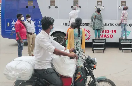  ??  ?? People get their nasal swab samples taken at a mobile testing centre in Hyderabad, India, on Friday.