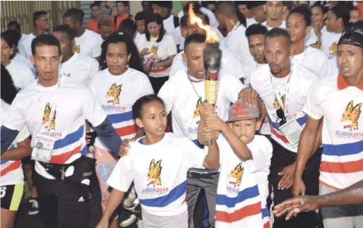  ?? FOTO FUENTE EXTERNA | DISEÑO JULIO ANÍBAL RAMÍREZ ?? Dos niños encabezan el pelotón portando el Fuego Patrio a su llegada a primera noche a Salcedo, escenario principal de los XIV Juegos Nacionales.