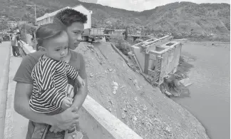  ?? SSB Photo ?? BUILD, BUILD. Siblings wander at Samoki Bridge in Bontoc, Mountain Province overlookin­g the Chico River. The Samoki bridge and a house were among the properties affected during the onslaught of typhoon Lawin two years ago.