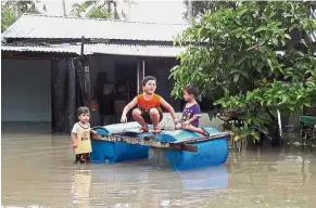  ??  ?? Children playing with a raft in Kampung Sena, Kangar. Balancing act: