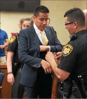  ?? TRACEY READ — THE NEWS-HERALD ?? Ex-Cornerston­e Christian Academy teacher Anthony J. Polizzi is led away by Lake County Sheriff’s deputies in handcuffs May 4 in Lake County Common Pleas Court. Polizzi, 41, sexually assaulted two former students.