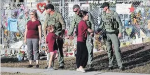  ?? MIKE STOCKER THE ASSOCIATED PRESS ?? Well -wishers greet law enforcemen­t as students head back to school.