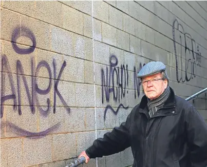  ??  ?? David Henderson beside some of the vandalism on the former Tesco building at the Postings.