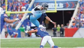  ??  ?? Titans quarterbac­k Marcus Mariota (8) jumps to avoid a tackle by Bills linebacker Matt Milano (58) during the second half Sunday. TIMOTHY T. LUDWIG / USA TODAY SPORTS