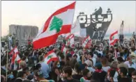  ?? (AFP) ?? Lebanese protesters gather to light the “October 17 torch” marking the one year anniversar­y of the beginning of a nationwide anti-government protest movement, in front of the devastated port of the capital Beirut where a massive explosion took place more than two months ago, on Saturday.