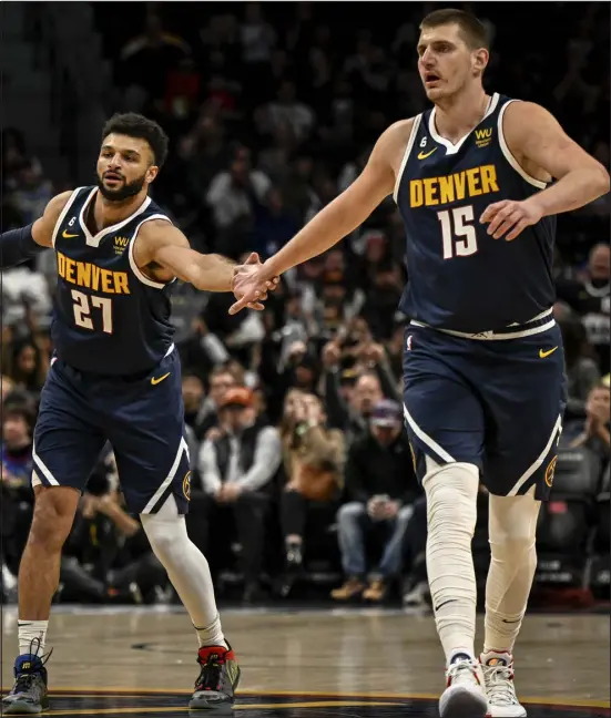  ?? AARON ONTIVEROZ — THE DENVER POST ?? The Nuggets’ Jamal Murray, left, high-fives Nikola Jokic after hitting a 3-pointer against the Portland Trail Blazers during the first quarter at on Tuesday at Ball Arena in Denver.