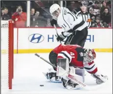  ?? Associated Press ?? The Kings’ Anze Kopitar (11) shoots the puck past New Jersey Devils goaltender Vitek Vanecek (41) during the first period on Thursday in Newark, N.J. The Kings lost 4-3 in overtime.