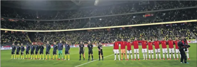  ??  ?? Las seleccione­s de Suecia y España escuchan los himnos nacionales antes de comenzar el partido en el Friends Arena de Solna.