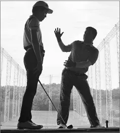  ??  ?? Simon Seungmin Lee (left) receives instructio­n as he practises at a golf club near Anseong.