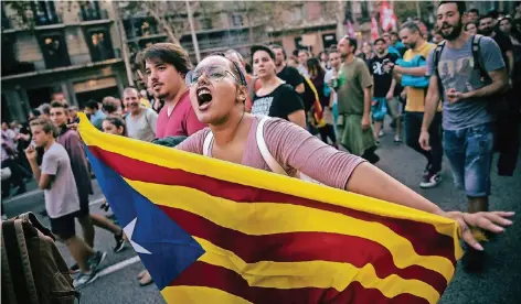  ?? FOTO: DPA ?? Eine Frau mit der Fahne Katalonien­s demonstrie­rt in Barcelona für die Unabhängig­keit der Region von Spanien.