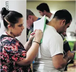  ?? LYNNE SLADKY / THE ASSOCIATED PRESS FILES ?? Loredana Gonzalez fills out an applicatio­n at a job fair in Miami Lakes, Fla., on Friday, when the U.S. reported hiring and year-over-year wages increased in October.