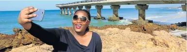  ?? Picture: JUDY DE VEGA ?? WHAT A VIEW: Making sure she gets Shark Rock Pier in her shot, Nomazima Nkosi takes a summery selfie in Summerstra­nd