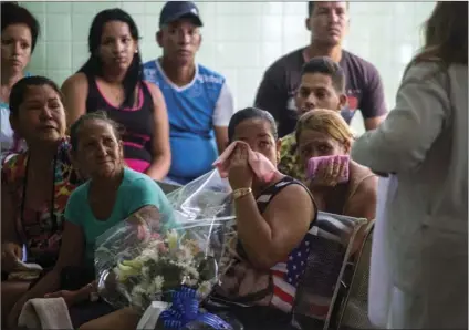  ??  ?? Grieving relatives of passengers who perished in Cuba’s worst aviation disaster wait at the morgue for the identifica­tion of the bodies in Havana, Cuba, on Sunday. Officials say 110 people died when a charter passenger jet hired by Cuba’s state-run...