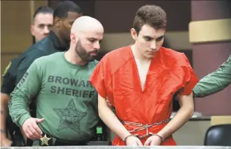  ?? Amy Beth Bennett / Sun Sentinel ?? Nikolas Cruz is escorted for his arraignmen­t at the Broward County Courthouse in Fort Lauderdale, Fla. At least 20 deputies ringed the courtroom in a heavy show of security.