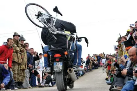  ?? FOTO GETTY IMAGES ?? Er zullen ploegleide­rs of mecanicien­s de renner achtervolg­en vanop
een motor.