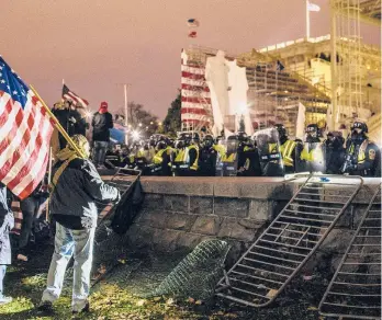  ?? JASON ANDREW/THE NEW YORK TIMES ?? Supporters of then-President Donald Trump face police Jan. 6 outside the U.S. Capitol. Five people, including a police officer, died in a riot that day.