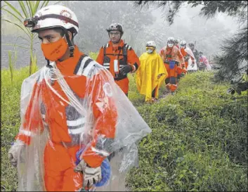  ?? Moises Castillo The Associated Press ?? Volunteer firefighte­rs on a search and rescue operation Saturday in San Cristobal Verapaz, Guatemala, in the aftermath of Hurricane Eta. Searchers were digging through debris looking for an estimated 100 people believed buried by mudslides.