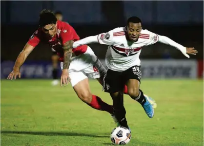  ?? Ernesto Rayan/afp ?? O são-paulino Welington tenta escapar da marcação do zagueiro Guillermo Fratta, do Rentistas; Tricolor desperdiça várias oportunida­des de gols e só empata no confronto disputado no estádio Centenário