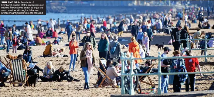  ?? ?? SUN AND SEA: Residents of Edinburgh dusted off the deckchairs and flocked to Portobello Beach to enjoy the warm weather, although a brisk sea breeze meant jackets were still required