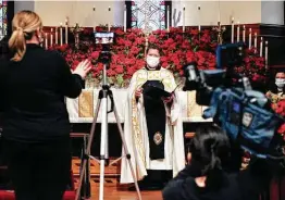  ?? Tom Reel / Staff photograph­er ?? The Rev. Matthew Wise at St. Mark's Episcopal Church waits for his cue to record the Christmas Day service on Wednesday for a virtual presentati­on in San Antonio. Many churches plan regular services in person.