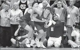  ?? Streeter Lecka Getty Images ?? WENDELL MOORE, right, is corralled by Jordan Goldwire after making the winning layup to lift No. 7 Duke over North Carolina 98-96 in overtime.