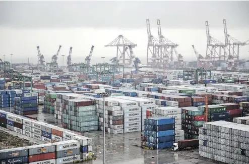  ?? QILAI SHEN / BLOOMBERG FILES ?? Shipping containers stacked at the Guangzhou Nansha Container Port. While many analysts see clouds lifting for emerging markets, the tariffs battle between the U.S. and China remains a “wild card,” according to Jpmorgan strategist­s.