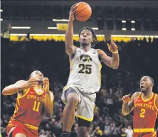  ?? Charlie Neibergall / Associated Press ?? Iowa’s Tyler Cook, who scored 26 points, drives between Iowa State’s Talen Horton-Tucker (11) and Cameron Lard.