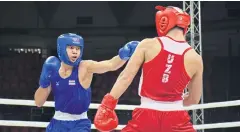  ??  ?? Weerapon Jongjohor, left, throws a punch at Navo Tamazov of Uzbekistan.